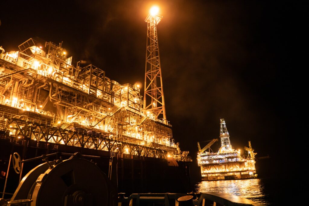 FPSO tanker vessel near Oil platform Rig at night. Offshore oil and gas industry